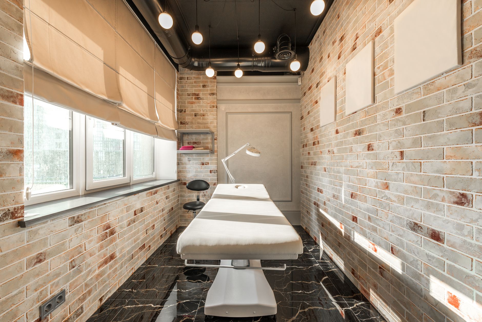 Heller Kosmetik-Innenraum mit Behandlungsliege und natürlichen Materialien